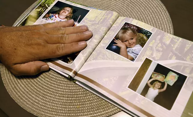 Robert Olds, uncle of Rikki Olds, who was fatally shot along with nine other people at a grocery store in Boulder, Colo., in 2021, looks through a memorial scrapbook in Lafayette, Colo., Tuesday, Aug. 27, 2024. (AP Photo/Thomas Peipert)