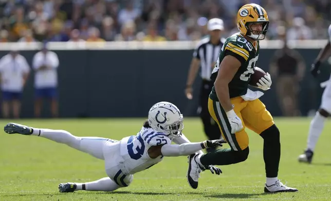 Green Bay Packers tight end Tucker Kraft (85) tries to escape from Indianapolis Colts cornerback Kenny Moore II (23) after making a catch during the second half of an NFL football game Sunday, Sept. 15, 2024, in Green Bay, Wis. (AP Photo/Matt Ludtke)