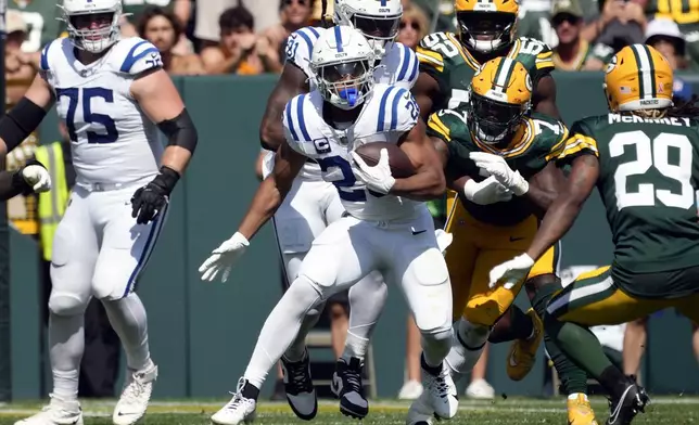 Indianapolis Colts running back Jonathan Taylor (28) runs past Green Bay Packers linebacker Quay Walker (7) for a first down during the first half of an NFL football game Sunday, Sept. 15, 2024, in Green Bay, Wis. (AP Photo/Morry Gash)