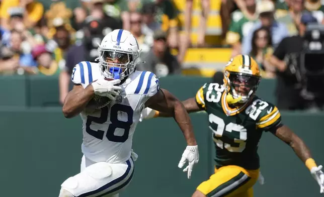 Indianapolis Colts running back Jonathan Taylor (28) runs from Green Bay Packers cornerback Jaire Alexander (23) during the second half of an NFL football game Sunday, Sept. 15, 2024, in Green Bay, Wis. (AP Photo/Morry Gash)