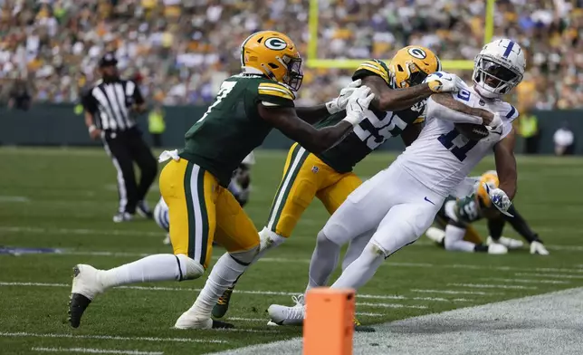 Indianapolis Colts wide receiver Michael Pittman Jr. (11) is pushed of of bounds short of the goal line Green Bay Packers defensive backs Kitan Oladapo (27) and Keisean Nixon (25) after a catch during the second half of an NFL football game Sunday, Sept. 15, 2024, in Green Bay, Wis. (AP Photo/Matt Ludtke)