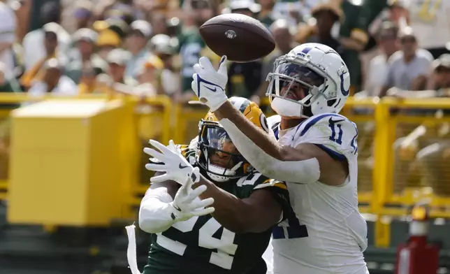 Green Bay Packers cornerback Carrington Valentine (24) and Indianapolis Colts wide receiver Michael Pittman Jr. (11) battle for a pass during the second half of an NFL football game Sunday, Sept. 15, 2024, in Green Bay, Wis. (AP Photo/Mike Roemer)