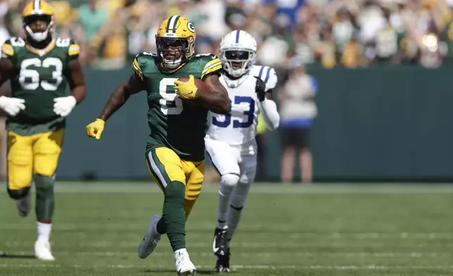 Green Bay Packers running back Josh Jacobs (8) runs for a first down as Indianapolis Colts cornerback Samuel Womack III (33) gives chase during the first half of an NFL football game Sunday, Sept. 15, 2024, in Green Bay, Wis. (AP Photo/Matt Ludtke)