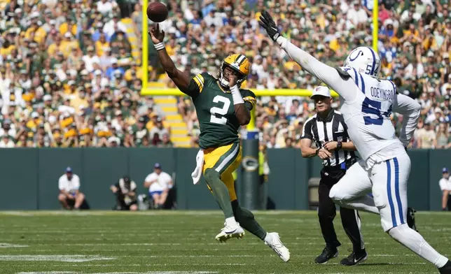 Green Bay Packers quarterback Malik Willis (2) throws on the run as Indianapolis Colts defensive end Dayo Odeyingbo (54) defends during the second half of an NFL football game Sunday, Sept. 15, 2024, in Green Bay, Wis. (AP Photo/Morry Gash)