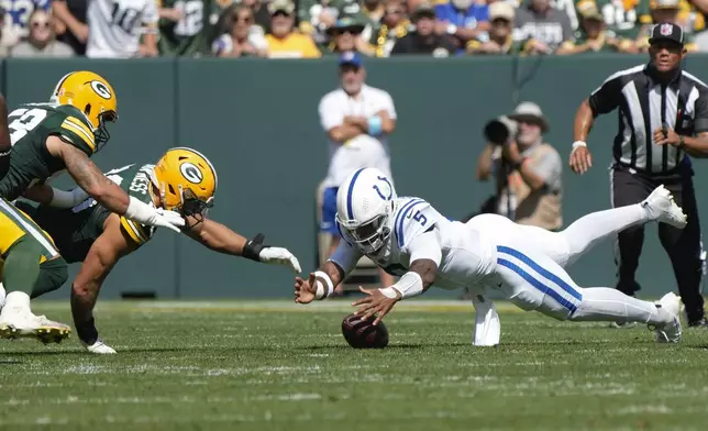 Indianapolis Colts quarterback Anthony Richardson (5) battles Green Bay Packers' Lukas Van Ness (90) and Isaiah McDuffie (58), left, as he recovers his own fumble during the first half of an NFL football game Sunday, Sept. 15, 2024, in Green Bay, Wis. (AP Photo/Morry Gash)