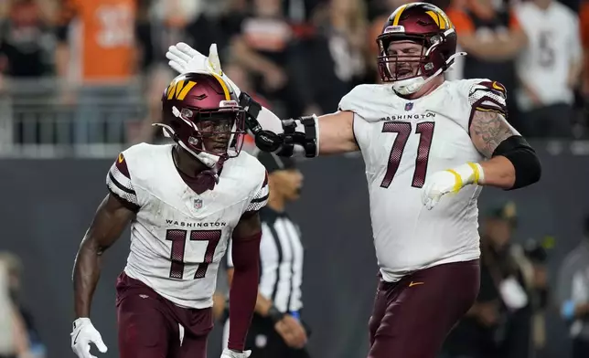 Washington Commanders wide receiver Terry McLaurin (17) celebrates with teammate Andrew Wylie (71) after catching a 27-yard touchdown pass during the second half of an NFL football game against the Cincinnati Bengals, Monday, Sept. 23, 2024, in Cincinnati. (AP Photo/Carolyn Kaster)