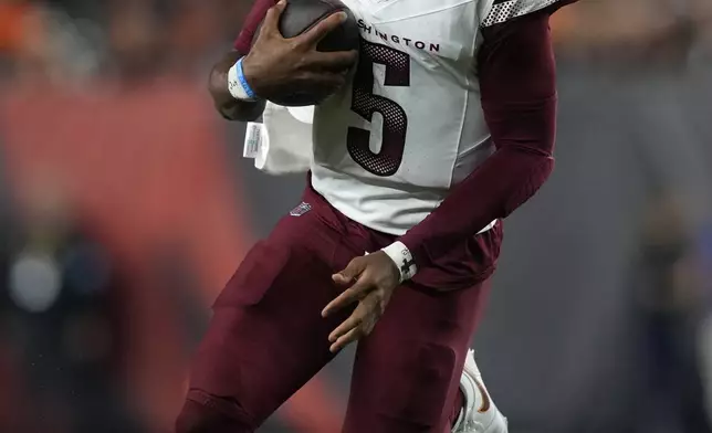 Washington Commanders quarterback Jayden Daniels (5) scrambles up field during the second half of an NFL football game against the Cincinnati Bengals, Monday, Sept. 23, 2024, in Cincinnati. (AP Photo/Carolyn Kaster)