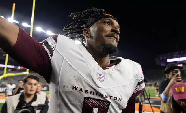 Washington Commanders quarterback Jayden Daniels (5) greets fans as he walks off the field after an NFL football game against the Cincinnati Bengals, Monday, Sept. 23, 2024, in Cincinnati. The Commanders won 38-33. (AP Photo/Carolyn Kaster)