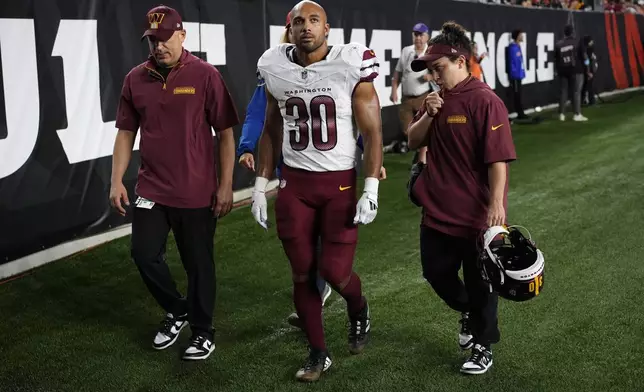 Washington Commanders running back Austin Ekeler (30) walks off the field after getting injured during the second half of an NFL football game against the Cincinnati Bengals, Monday, Sept. 23, 2024, in Cincinnati. (AP Photo/Carolyn Kaster)