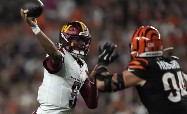 Washington Commanders quarterback Jayden Daniels (5) throws a pass over Cincinnati Bengals defensive end Sam Hubbard (94) during the second half of an NFL football game, Monday, Sept. 23, 2024, in Cincinnati. (AP Photo/Carolyn Kaster)