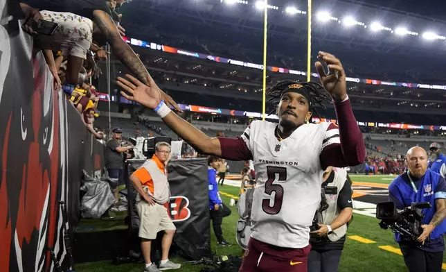 Washington Commanders quarterback Jayden Daniels (5) greets fans as he walks off the field after an NFL football game against the Cincinnati Bengals, Monday, Sept. 23, 2024, in Cincinnati. The Commanders won 38-33. (AP Photo/Carolyn Kaster)