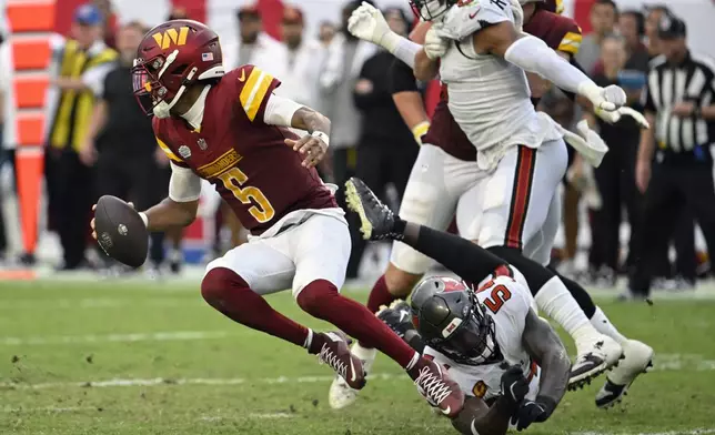 Washington Commanders quarterback Jayden Daniels (5) slips from a tackle by Tampa Bay Buccaneers linebacker Lavonte David during the second half of an NFL football game Sunday, Sept. 8, 2024, in Tampa, Fla. (AP Photo/Jason Behnken)