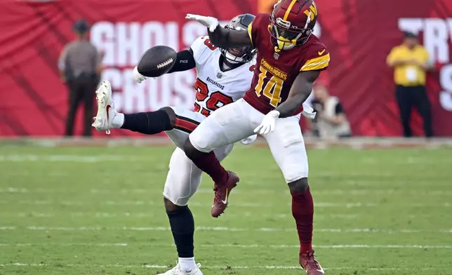 Tampa Bay Buccaneers safety Christian Izien, left, breaks up a pas intended for Washington Commanders wide receiver Olamide Zaccheaus (14) during the second half of an NFL football game Sunday, Sept. 8, 2024, in Tampa, Fla. (AP Photo/Jason Behnken)