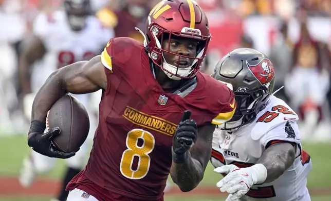 Washington Commanders running back Brian Robinson Jr. (8) runs past Tampa Bay Buccaneers linebacker K.J. Britt, right, during the second half of an NFL football game Sunday, Sept. 8, 2024, in Tampa, Fla. (AP Photo/Jason Behnken)