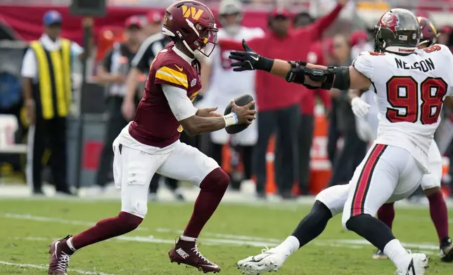 Washington Commanders quarterback Jayden Daniels, left, scrambles past Tampa Bay Buccaneers linebacker Anthony Nelson (98) during the first half of an NFL football game Sunday, Sept. 8, 2024, in Tampa, Fla. (AP Photo/Chris O'Meara)