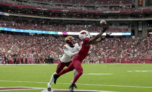 Arizona Cardinals wide receiver Marvin Harrison Jr., right, pulls in a touchdown pass as Washington Commanders cornerback Noah Igbinoghene defends during the first half of an NFL football game, Sunday, Sept. 29, 2024, in Glendale, Ariz. (AP Photo/Rick Scuteri)