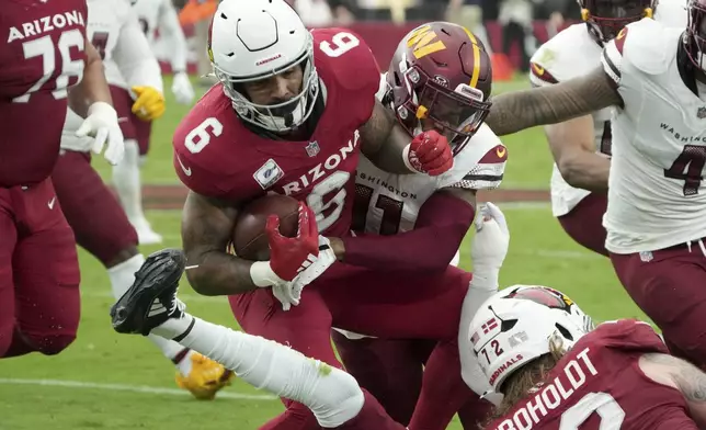 Arizona Cardinals running back James Conner (6) is tackled by Washington Commanders safety Jeremy Chinn (11) during the first half of an NFL football game, Sunday, Sept. 29, 2024, in Glendale, Ariz. (AP Photo/Rick Scuteri)