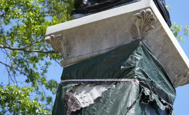 Small sections of the century-old Confederate memorial marble statue are seen underneath the weather-worn tarp covering the monument in Grenada, Miss., April 12, 2023. (AP Photo/Rogelio V. Solis)