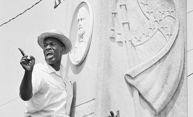 FILE - Robert Green, a leader in the Southern Christian Leadership Conference, speaks from the Confederate Memorial statue in the Grenada town square in Mississippi, June 14, 1966, after planting an American Flag above the bas relief of Confererate President Jefferson Davis. (AP Photo, File)