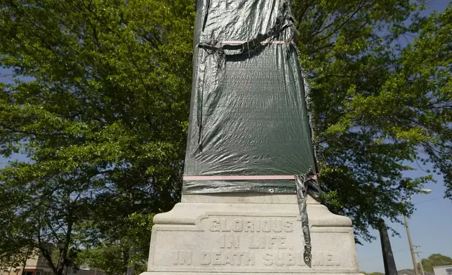 A century-old Confederate memorial statue is outlined underneath the weather-worn tarp covering the monument in Grenada, Miss., April 12, 2023. (AP Photo/Rogelio V. Solis)