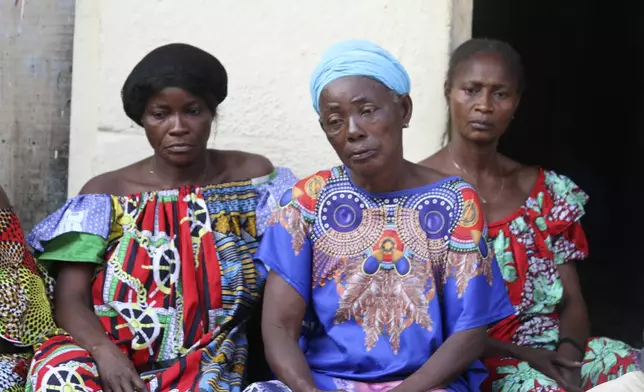 Madeleine Mbalaka, centre, whose son was killed during the recently attempted jailbreak sits outside her house with family members in Kinshasa, Congo, Tuesday, Sept. 3, 2024. Families of those that died in what Congo's authorities described as an attempted jailbreak in the country's biggest prison demand answers from the government, as criticism mounts over what activists describe as inhumane conditions in Congo's overcrowded penitentiary facilities. (AP Photo/Benz Bokote)