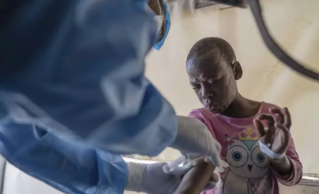 FILE - A health worker attends to an mpox patient, at a treatment center in Munigi, eastern Congo, Aug. 19, 2024. (AP Photo/Moses Sawasawa, File)