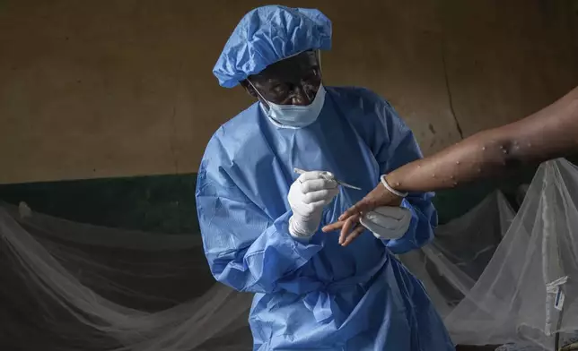 Atumisi Anaclet treats a sex worker with mpox on Sept. 4, 2024, in a hospital in Kamituga, in eastern Congo's South Kivu province, which is the epicenter of the world's latest outbreak of the disease. (AP Photo/Moses Sawasawa)