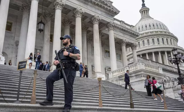 A U.S. Capitol Police officer stands watch as lawmakers leave the House of Representatives after voting on an interim spending bill to avoid a government shutdown next week, at the Capitol in Washington, Wednesday, Sept. 25, 2024. (AP Photo/J. Scott Applewhite)