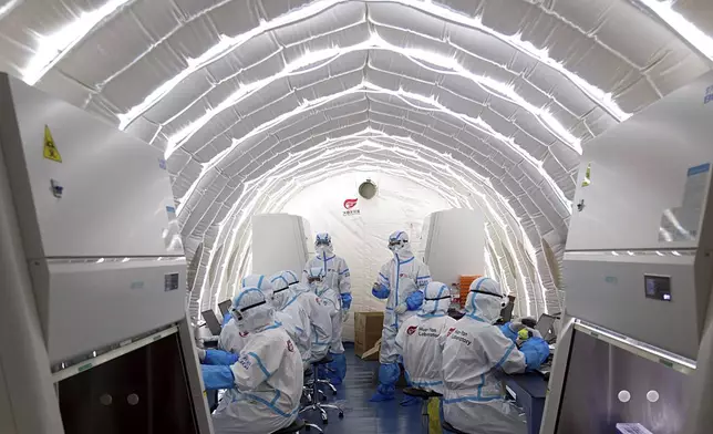 FILE - In this file photo released by China's Xinhua News Agency, staff members work in an inflatable COVID-19 testing lab provided by Chinese biotech company BGI Genomics, a subsidiary of BGI Group, in Beijing, June 23, 2020. (Chen Zhonghao/Xinhua via AP, File)