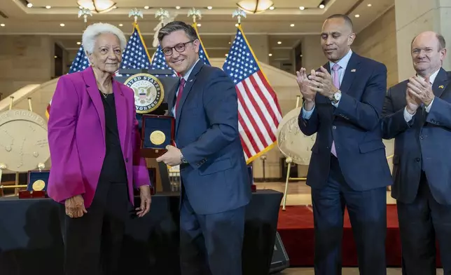 House Speaker Mike Johnson, R-La., center, presents a Congressional Gold Medal to Ann Hammond, daughter of NASA's Dorothy Vaughan, at a ceremony to honor the Black women mathematicians of NASA who contributed to the space race and who were the subject of the book and movie "Hidden Figures," at the Capitol in Washington, Wednesday, Sept. 18, 2024. They are joined by House Minority Leader Hakeem Jeffries, D-N.Y., second from right, and Sen. Chris Coons, D-Del. (AP Photo/J. Scott Applewhite)