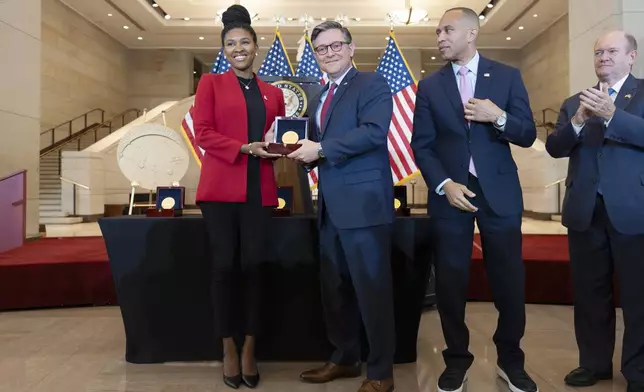 House Speaker Mike Johnson, R-La., center, stands with Dr. Christon Darden, left, to present a Congressional Gold Medal on behalf of her grandmother Christine Darden as they honor the Black women mathematicians of NASA who contributed to the space race and who were the subject of the book and movie "Hidden Figures," at the Capitol in Washington, Wednesday, Sept. 18, 2024. They are joined by House Minority Leader Hakeem Jeffries, D-N.Y., second from right, and Sen. Chris Coons, D-Del. (AP Photo/J. Scott Applewhite)