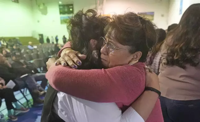 School teacher Sherry Crutcher, right, hugs Terri Ann Cota at a memorial service for Cota's father, Marvin, on March 14, 2024, in Owyhee, Nev., on the Duck Valley Indian Reservation that straddles the Nevada-Idaho border. (AP Photo/Rick Bowmer)