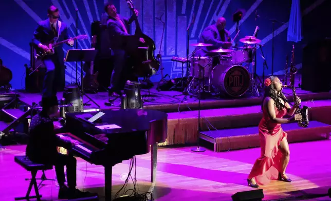 Members of the band Postmodern Jukebox perform on stage at the Ryman Auditorium during a concert in Nashville, Tenn., on July 30, 2024. (AP Photo/Luis Andres Henao)