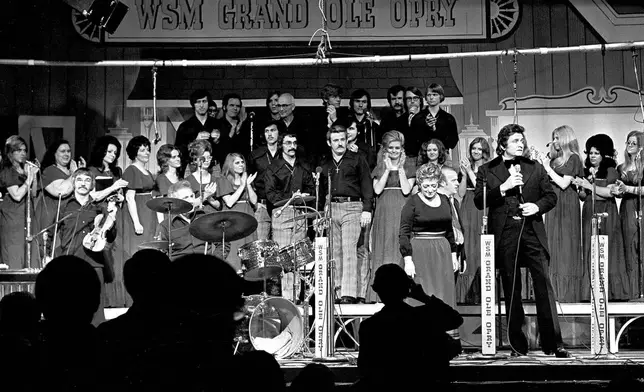 FILE - Country music stars, including Johnny Cash, foreground right, and Maybelle Carter, next to Cash, perform during the Grand Ole Opry's last show at Ryman Auditorium in Nashville, Tenn., March 18, 1974. (AP Photo/John Duricka)