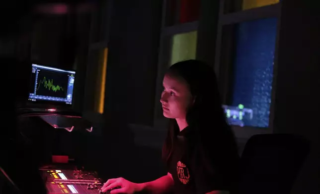 Sound engineer Amber Rhodes prepares before a concert at the Ryman Auditorium in Nashville, Tenn., on July 30, 2024. (AP Photo/Luis Andres Henao)