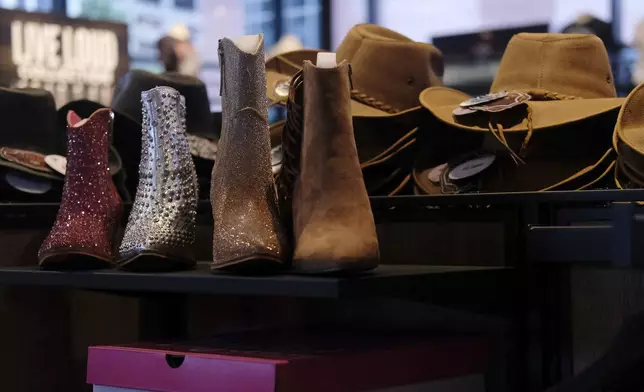 Cowboy hats and boots are displayed at the Ryman Auditorium gift shop in Nashville, Tenn., on July 30, 2024. (AP Photo/Luis Andres Henao)