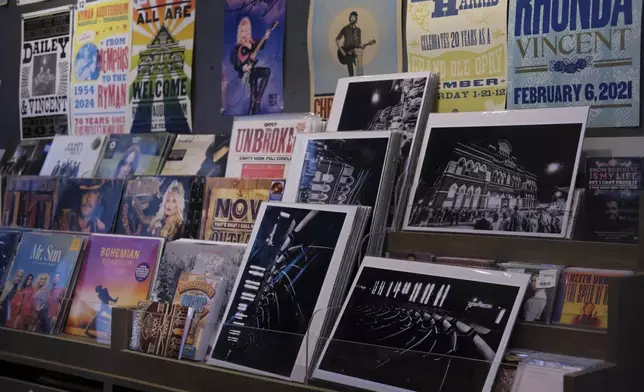 Posters of Dolly Parton and other artists who have played at the Ryman Auditorium are displayed at the concert venue's gift shop in Nashville, Tenn., on July 30, 2024. (AP Photo/Luis Andres Henao)