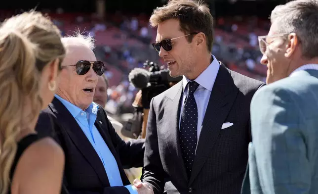 Dallas Cowboys team owner Jerry Jones, left, and analyst Tom Brady, center right, talk with others during team warmups before an NFL football game against the Cleveland Browns in Cleveland, Sunday, Sept. 8, 2024. (AP Photo/Sue Ogrocki)