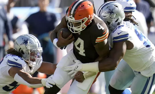 Cleveland Browns quarterback Deshaun Watson (4) is tackled by Dallas Cowboys defensive tackle Osa Odighizuwa, right, and others after a short carry in the first half of an NFL football game in Cleveland, Sunday, Sept. 8, 2024. (AP Photo/Sue Ogrocki)