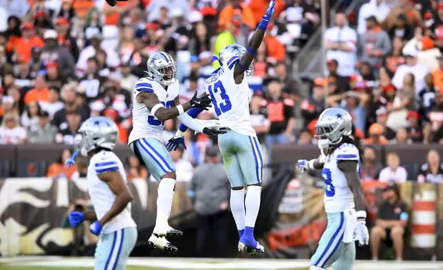 Dallas Cowboys' Juanyeh Thomas, center left, and DeMarvion Overshown (13) celebrate a stop against the Cleveland Browns in the second half of an NFL football game in Cleveland, Sunday, Sept. 8, 2024. (AP Photo/David Richard)