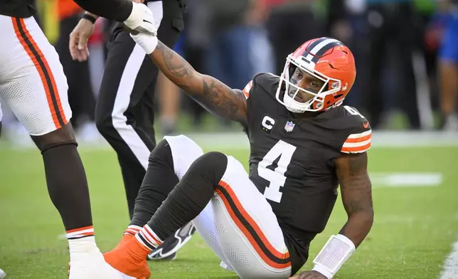 Cleveland Browns quarterback Deshaun Watson (4) is helped up by James Hudson III, left, after Watson threw an incomplete pass in the second half of an NFL football game against the Dallas Cowboys in Cleveland, Sunday, Sept. 8, 2024. (AP Photo/David Richard)