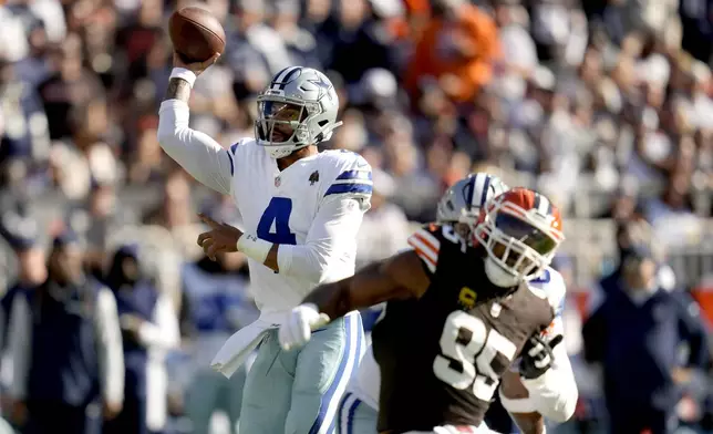 Dallas Cowboys quarterback Dak Prescott (4) throws a pass under pressure from Cleveland Browns defensive end Myles Garrett (95) in the first half of an NFL football game in Cleveland, Sunday, Sept. 8, 2024. (AP Photo/Sue Ogrocki)