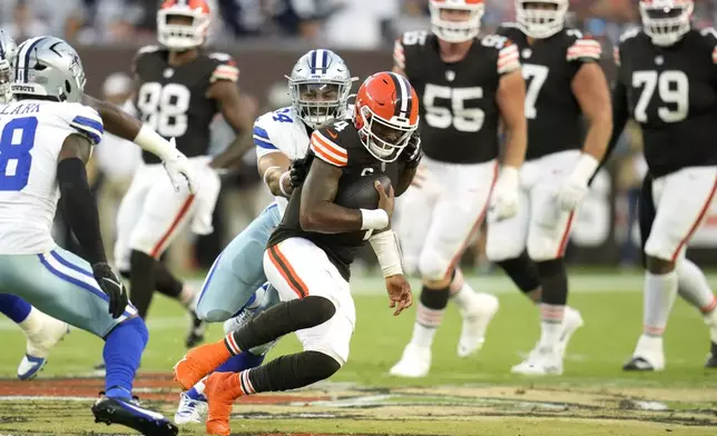 Cleveland Browns quarterback Deshaun Watson (4) is stopped after a short gain by Dallas Cowboys defensive end Marshawn Kneeland, rear, in the second half of an NFL football game in Cleveland, Sunday, Sept. 8, 2024. (AP Photo/Sue Ogrocki)