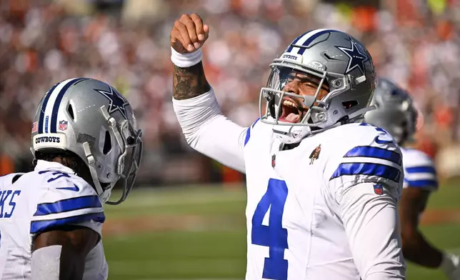 Dallas Cowboys quarterback Dak Prescott (4) celebrates after throwing a touchdown pass to wide receiver Brandin Cooks, left, in the first half of an NFL football game against the Cleveland Browns in Cleveland, Sunday, Sept. 8, 2024. (AP Photo/David Richard)