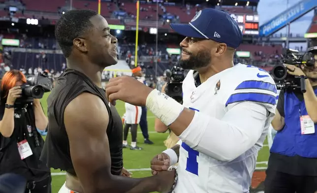 Cleveland Browns' Amari Cooper, left, and Dallas Cowboys' Dak Prescott, right, greet each other after their team's NFL football game in Cleveland, Sunday, Sept. 8, 2024. (AP Photo/Sue Ogrocki)