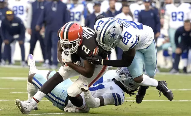 Cleveland Browns wide receiver Amari Cooper (2) is stopped after making a catch by Dallas Cowboys safety Malik Hooker (28) and cornerback Caelen Carson, rear, in the second half of an NFL football game in Cleveland, Sunday, Sept. 8, 2024. (AP Photo/Sue Ogrocki)