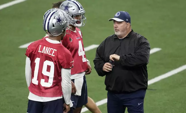 Dallas Cowboys quarterbacks Trey Lance (19) and Dak Prescott (4) talk with head coach Mike McCarthy during an NFL football practice at the team's training facility, Wednesday, Aug. 28, 2024, in Frisco, Texas. (AP Photo/Tony Gutierrez)