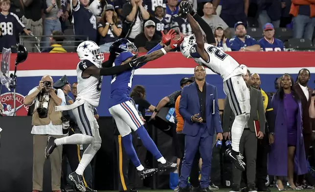 Dallas Cowboys cornerback Amani Oruwariye (27) intercepts a pass intended for New York Giants wide receiver Isaiah Hodgins (18) during the fourth quarter of an NFL football game, Thursday, Sept. 26, 2024, in East Rutherford, N.J. (AP Photo/Adam Hunger)