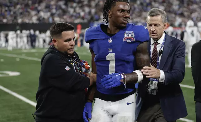 New York Giants wide receiver Malik Nabers (1) is helped off the field after an injury during the fourth quarter of an NFL football game against the Dallas Cowboys, Thursday, Sept. 26, 2024, in East Rutherford, N.J. (AP Photo/Adam Hunger)