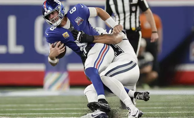 New York Giants quarterback Daniel Jones (8) is sacked by Dallas Cowboys defensive end Marshawn Kneeland (94) during the third quarter of an NFL football game, Thursday, Sept. 26, 2024, in East Rutherford, N.J. (AP Photo/Adam Hunger)